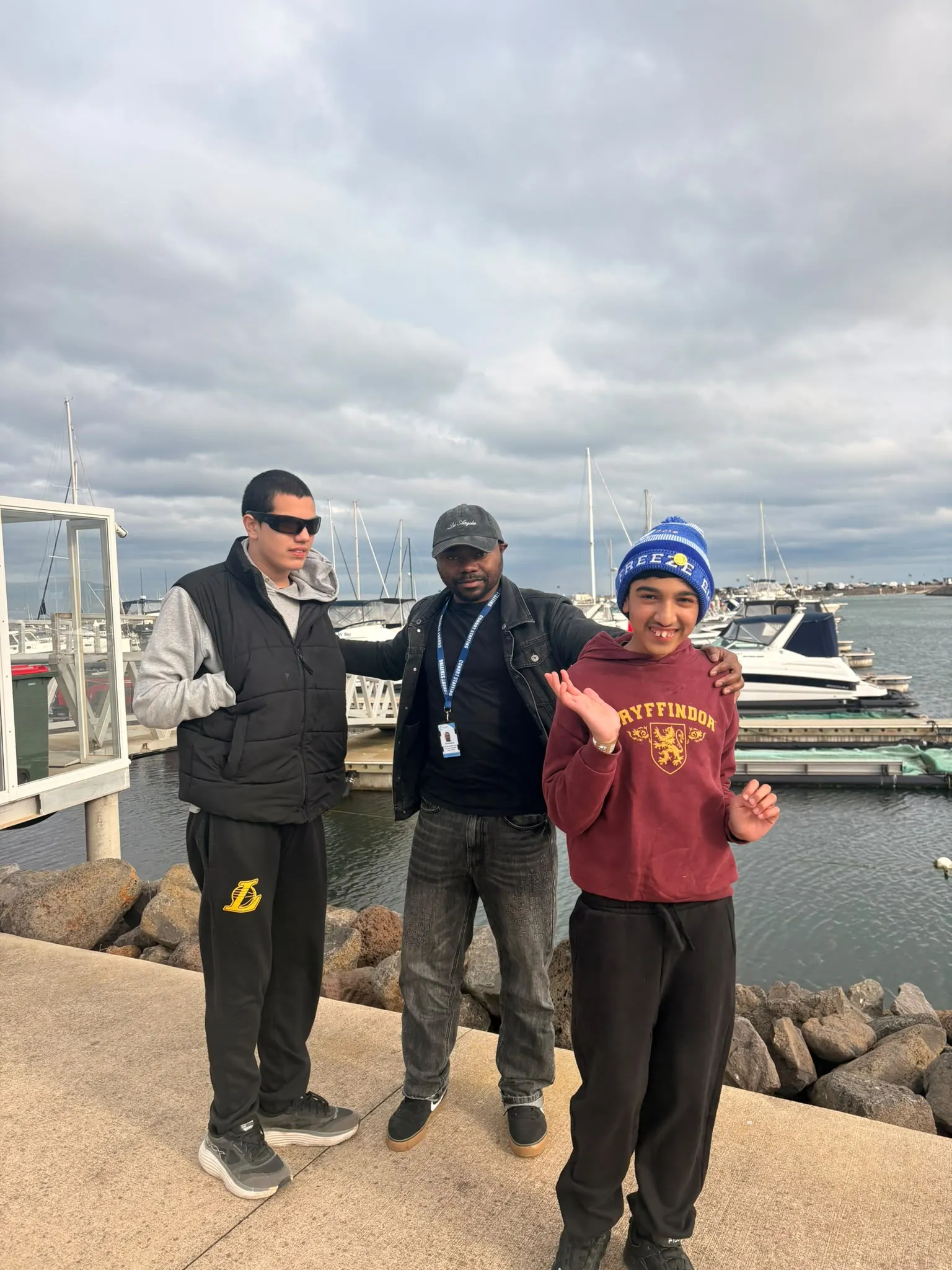 Participants and a support worker at a marina during a community outing