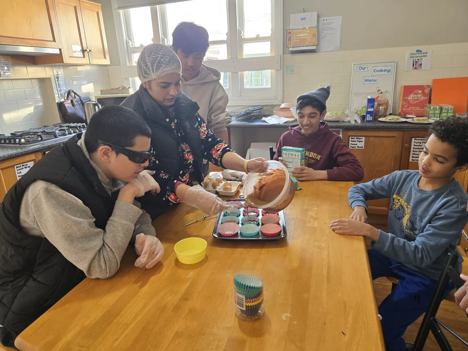 A participant showing off a cupcake fresh from the oven during a cooking session