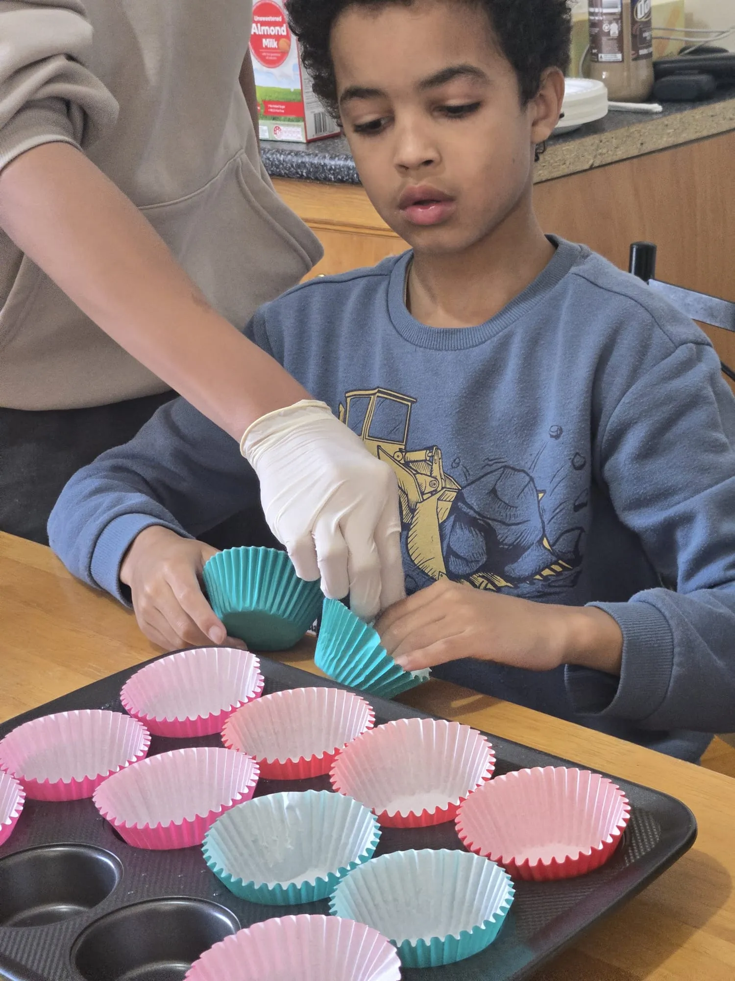 A participant holding a freshly baked cupcake made during a cooking session