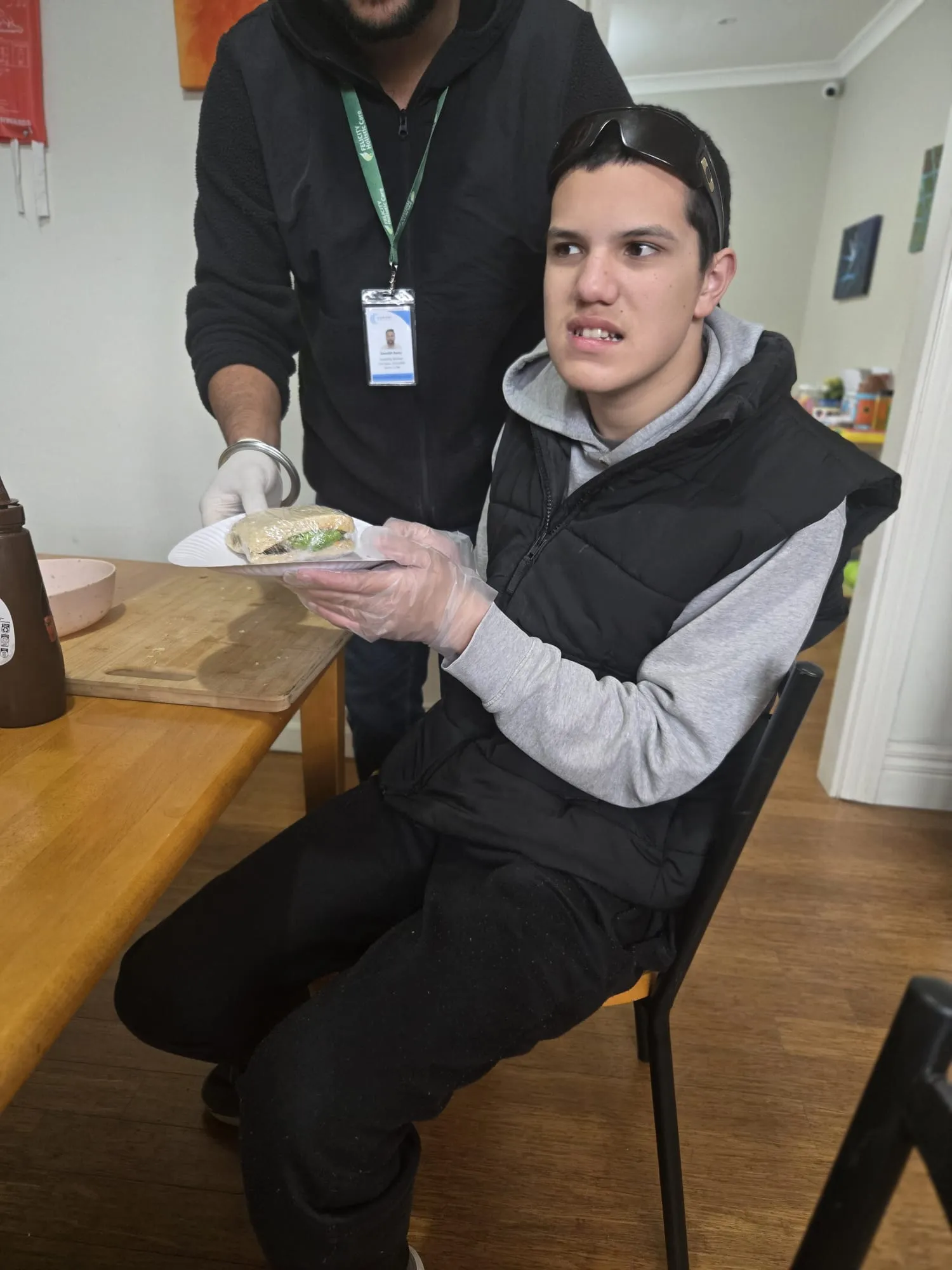 A participant slicing vegetables for a sandwich during a life skills session