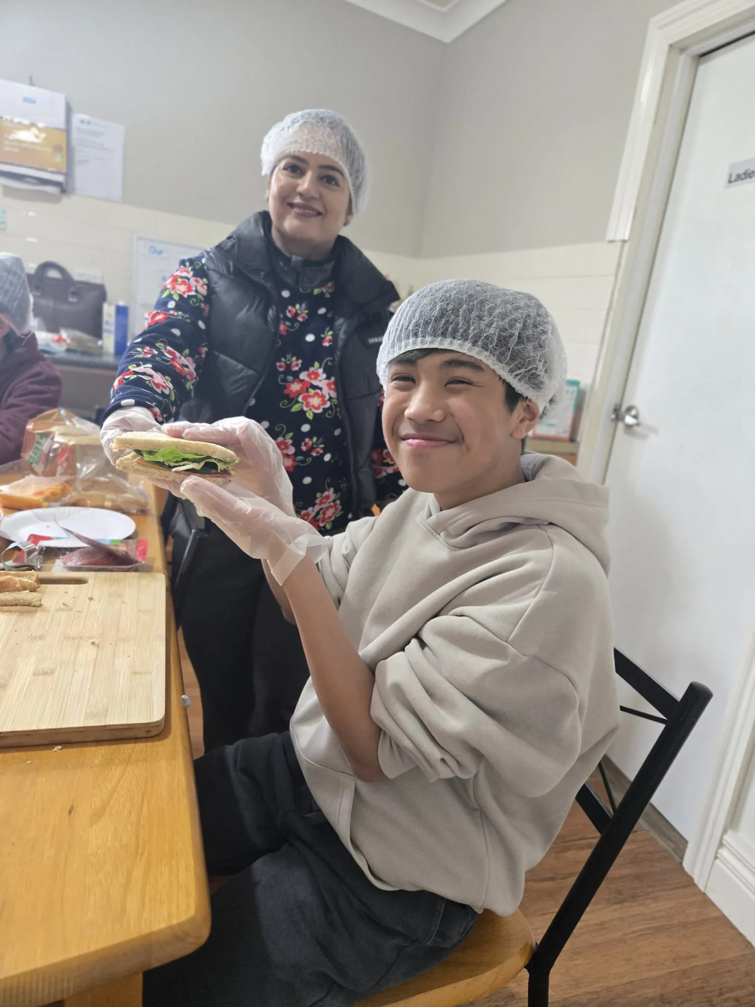 Participants assembling sandwiches with fresh vegetables during a cooking session