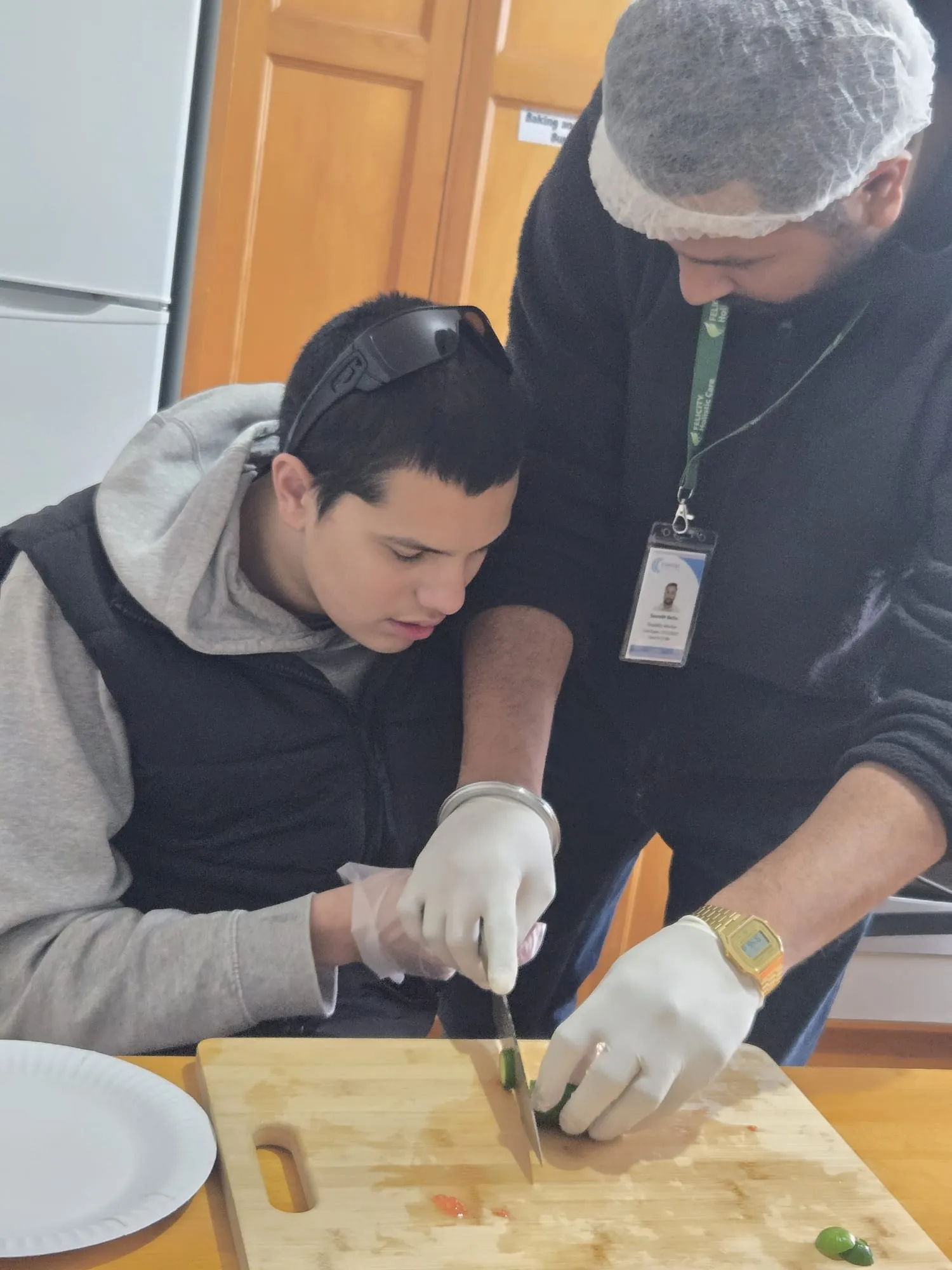 A participant slicing vegetables for a sandwich during a life skills session
