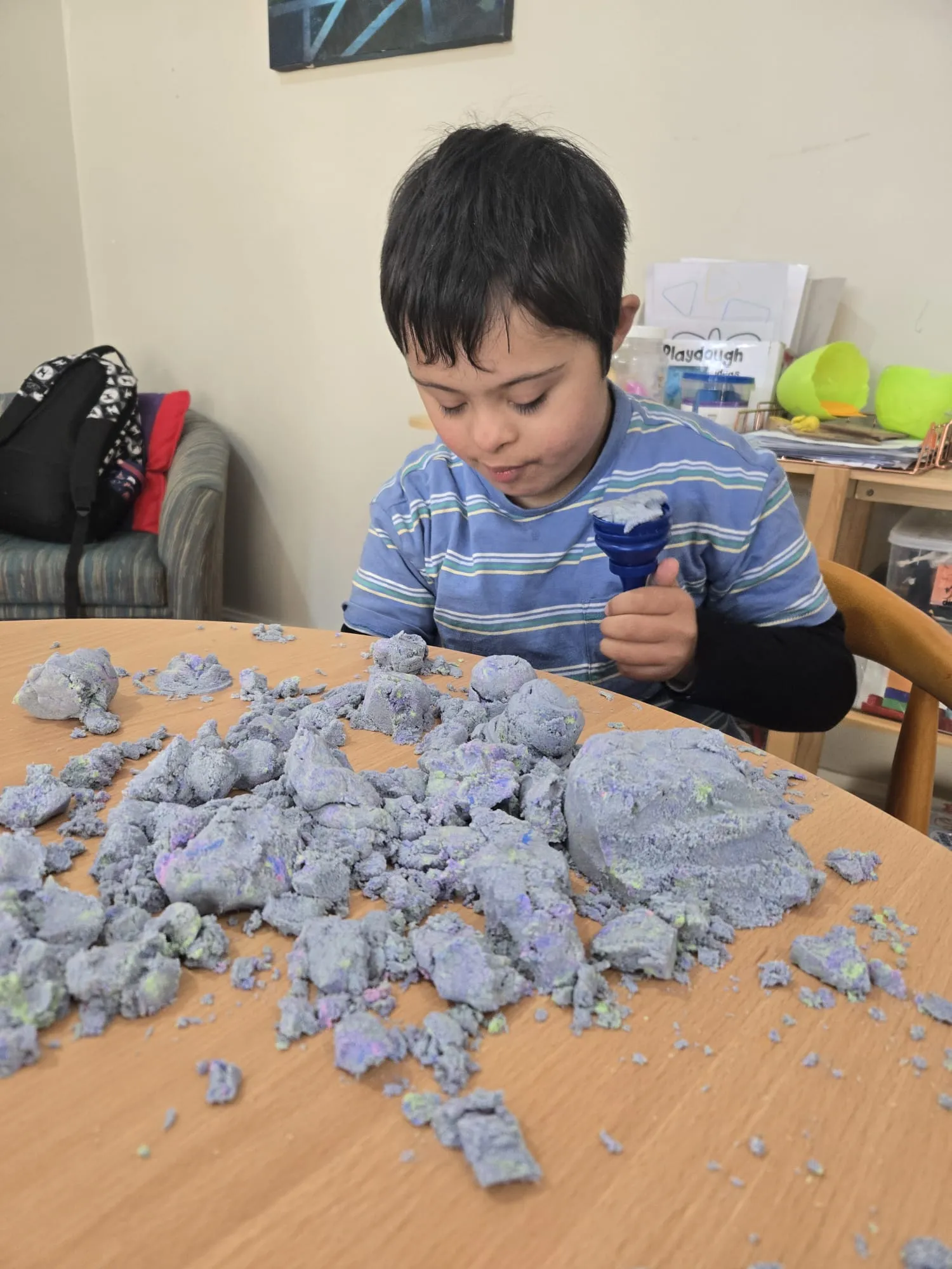 A participant engaging with kinetic sand during a sensory play session