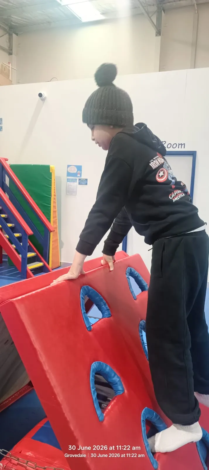 A participant engaging with a suspended balance board during an OT session