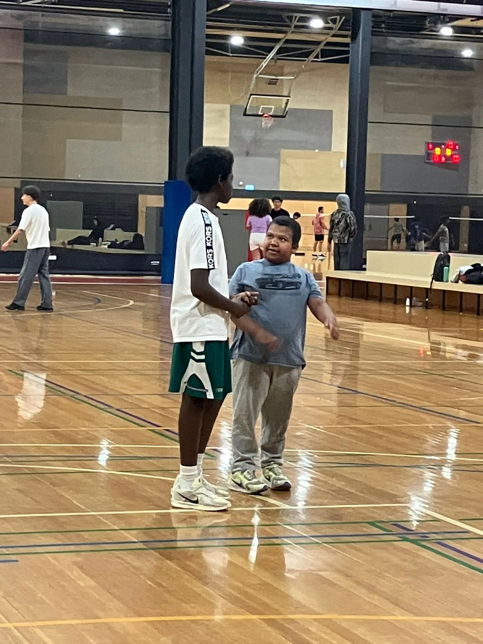 A participant dribbling a basketball during an indoor recreation session