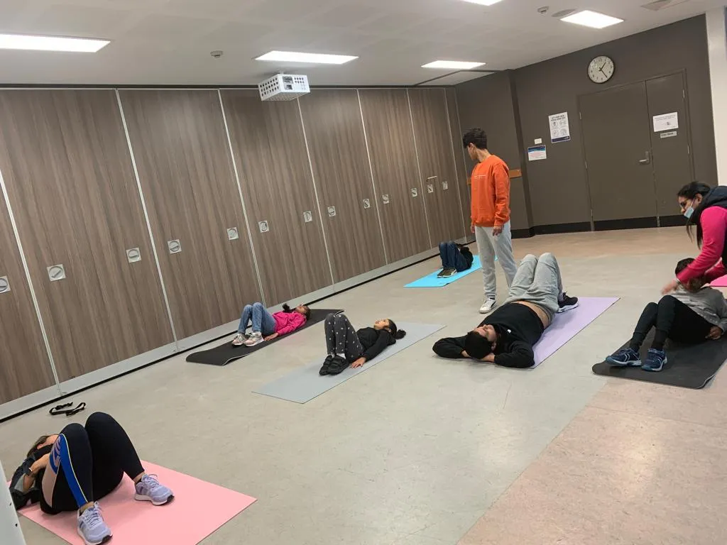 Participants stretching on yoga mats during a guided movement session